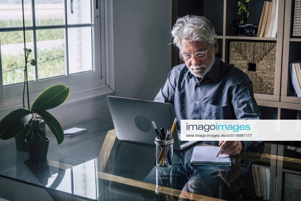 Businessman writing on note pad while working at home model released Symbolfoto property released SIPF02274