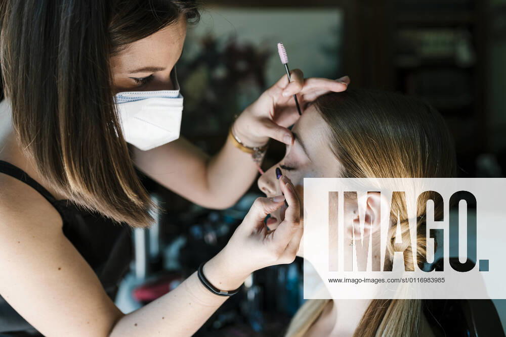 Female make-up artist applying eye shadow on young woman model released Symbolfoto property released EGAF02248