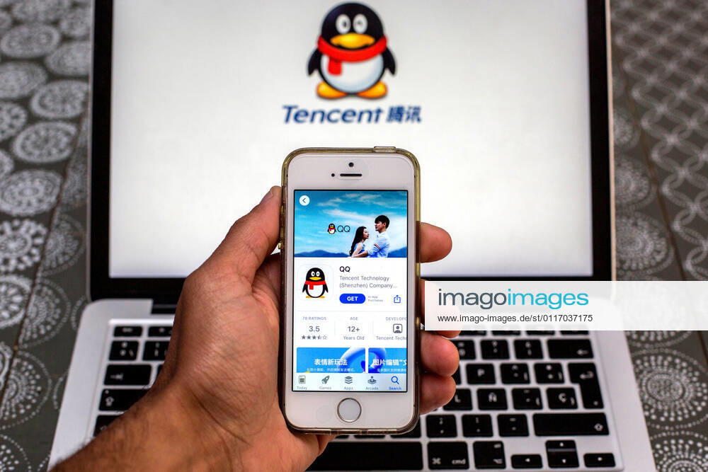 In this photo illustration, the Tencent QQ app in App Store seen displayed on a smartphone screen and a Tencent QQ logo on a laptop in the background. Barcelona Spain - ZUMAd159 20210430_zia_d159_005