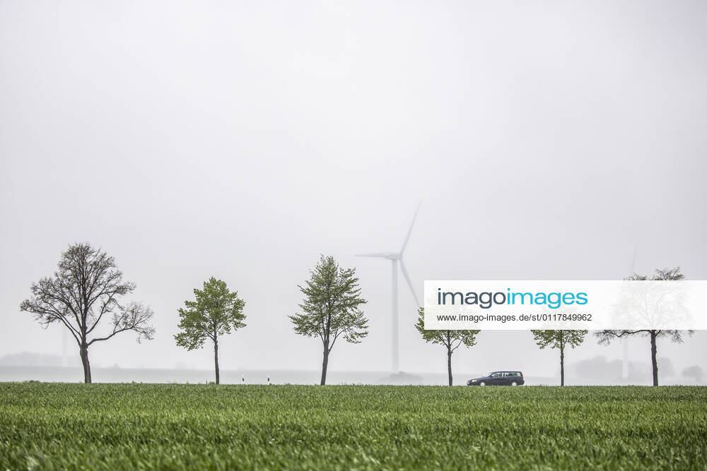 IMAGO Creative: Corporate: Klimaschutz, Digitalisierung und Urbanisierung Ein Auto zeichnet sich auf einer Landstrasse von Windraedern ab in Vierkirchen, 13.05.2021. Vierkirchen Deutschland