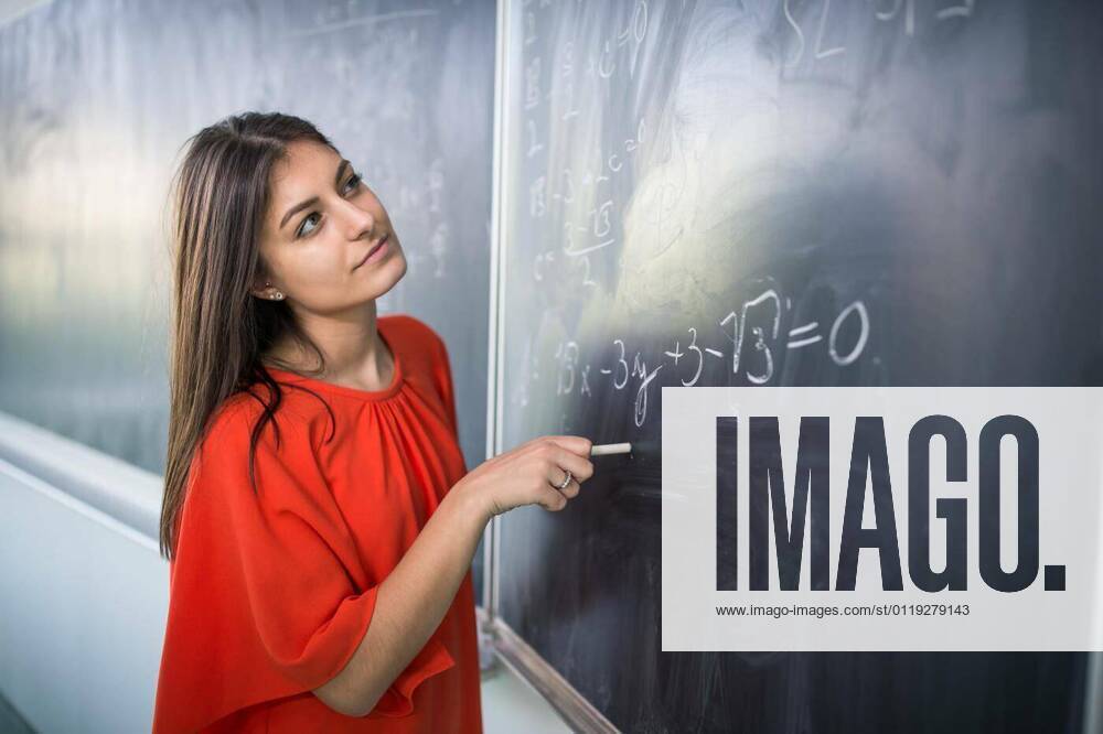 Pretty, young college student/young teacher writing on the chalkboard/blackboard during a math class model released, Symbolfoto, 28.01.2020 12:25:03,