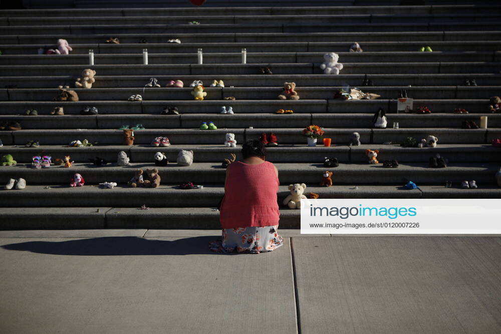 Regina Haasjes, of the Tla-O-Qui-Aht First Nation, pays her respects below the steps outside the legislature in Victoria, Tuesday, June 1, 2021. Shoes have been laid in honour of the 215 residential school children whose remains have been discovered near the facility in Kamloops, B.C. Victoria Canada - ZUMAc35_ 20210601_zaf_c35_130
