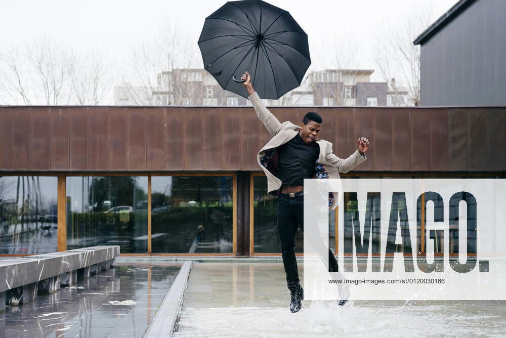 IMAGO Creative: Herbst in der Stadt Portrait of elegant black man with grey coat in the street looking away, Model released