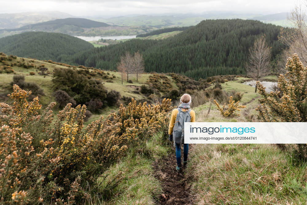 Girl with backpack walking through flower lined path in New Zealand Tutira, Hawke s Bay, New Zealand CR_JUCR210608A-757261-01 ,model released, Symbolfoto
