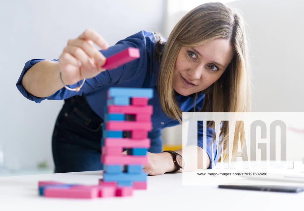 Businesswoman playing block removal game at office model released Symbolfoto property released GIOF12490