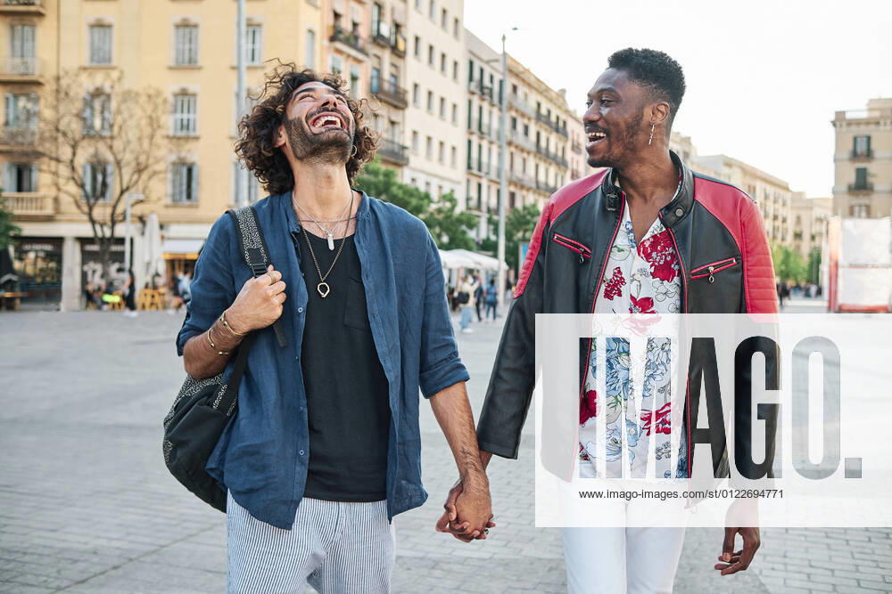 IMAGO Creative: Urban Diversity IMAGO Creative: Pride Month, Juni 2022, Pärchen und Familien Happy gay couple with holding hands walking on road model released Symbolfoto AGOF00128