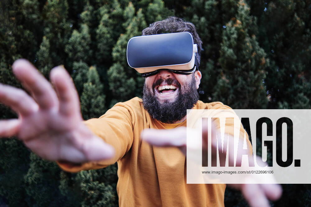 Playful man using VR glasses in garden model released Symbolfoto ASGF00316