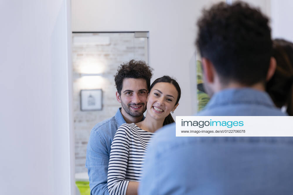 Cute couple embracing in front of the mirror at home model released Symbolfoto property released EIF01134