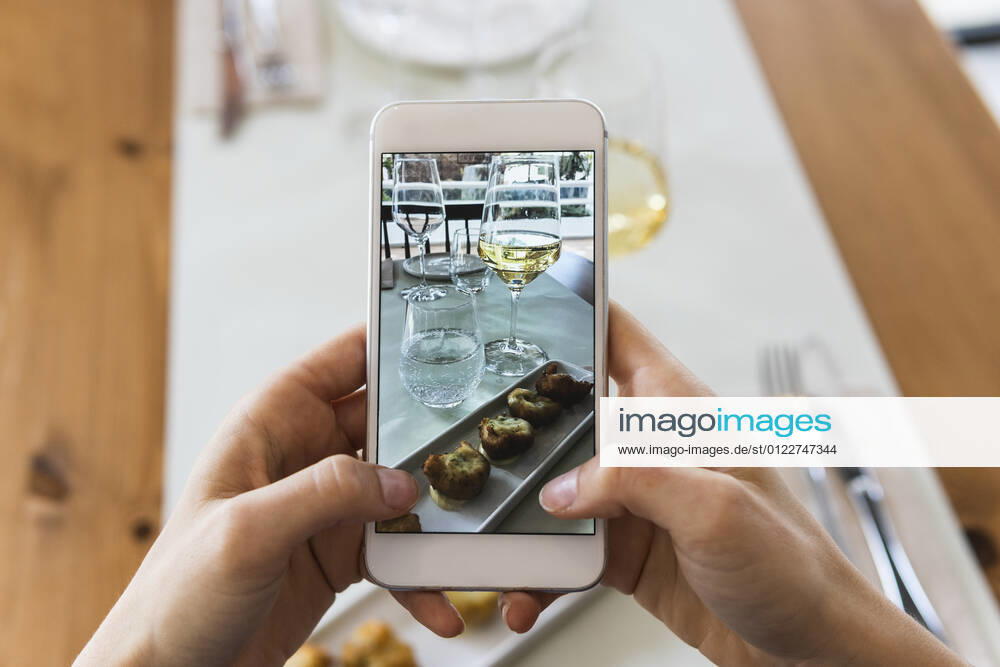IMAGO Creative, Food, Tapas Young woman photographing food through smart phone at restaurant model released Symbolfoto property released PNAF01790
