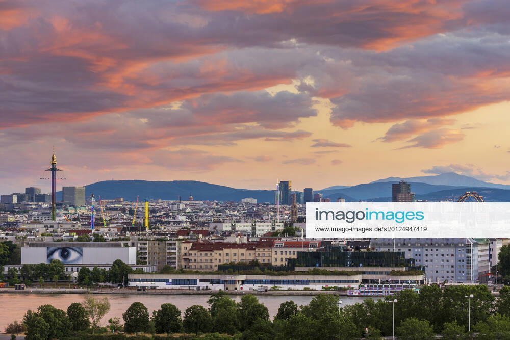 Sunset panorama of Vienna city center from North-East: , river Donau (Danube), island Donauinsel, amusement park Prater, tower Praterturm (carousel type Starflyer), Ferris Wheel, mountain Schneeberg (right) Wien, Vienna Wien Austria 00. overview