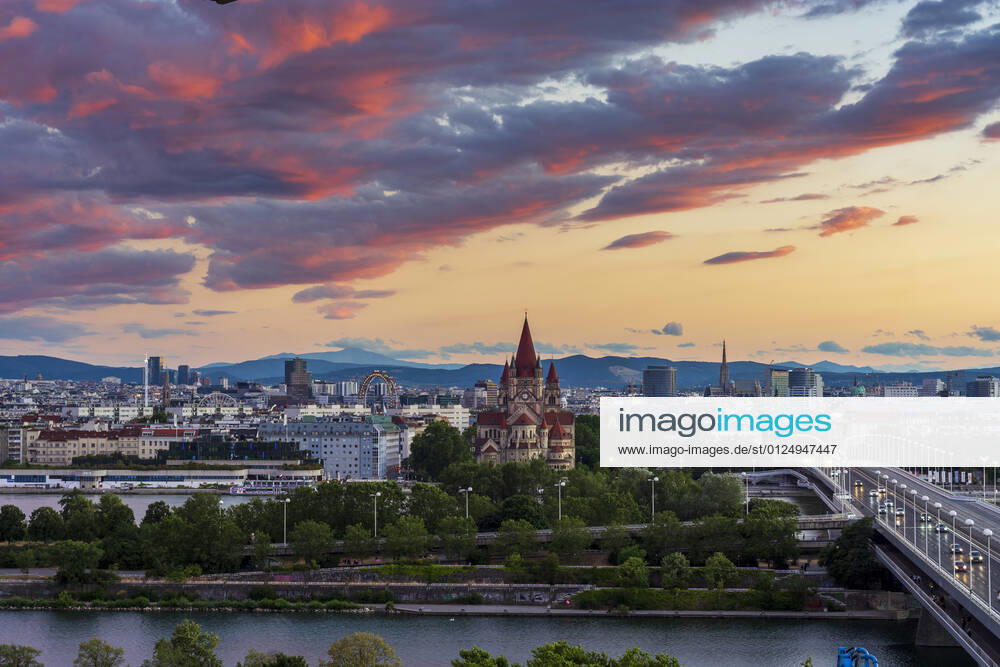 Sunset panorama of Vienna city center from North-East: , river Donau (Danube), island Donauinsel, bridge Reichsbrücke, amusement park Prater, Ferris Wheel, church Franz von Assisi, cathedral Stephansdom (St. Stephen s Cathedral) (from left to right) Wien, Vienna Wien Austria 00. overview