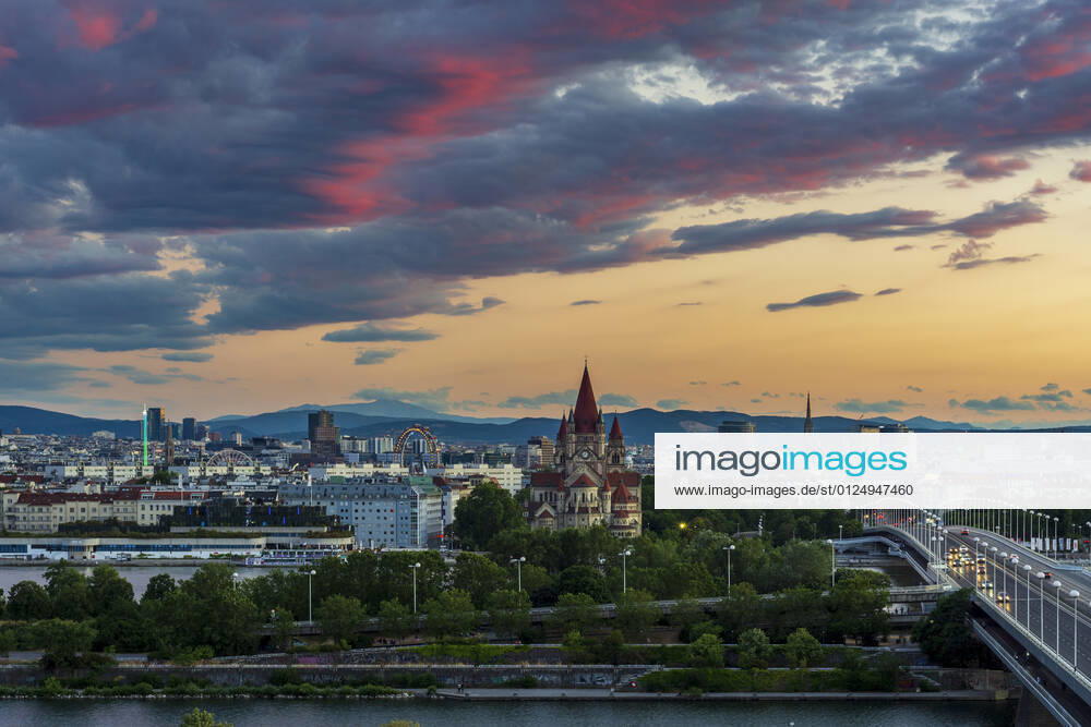 Sunset panorama of Vienna city center from North-East: , river Donau (Danube), island Donauinsel, bridge Reichsbrücke, amusement park Prater, Ferris Wheel, church Franz von Assisi, cathedral Stephansdom (St. Stephen s Cathedral) (from left to right) Wien, Vienna Wien Austria 00. overview