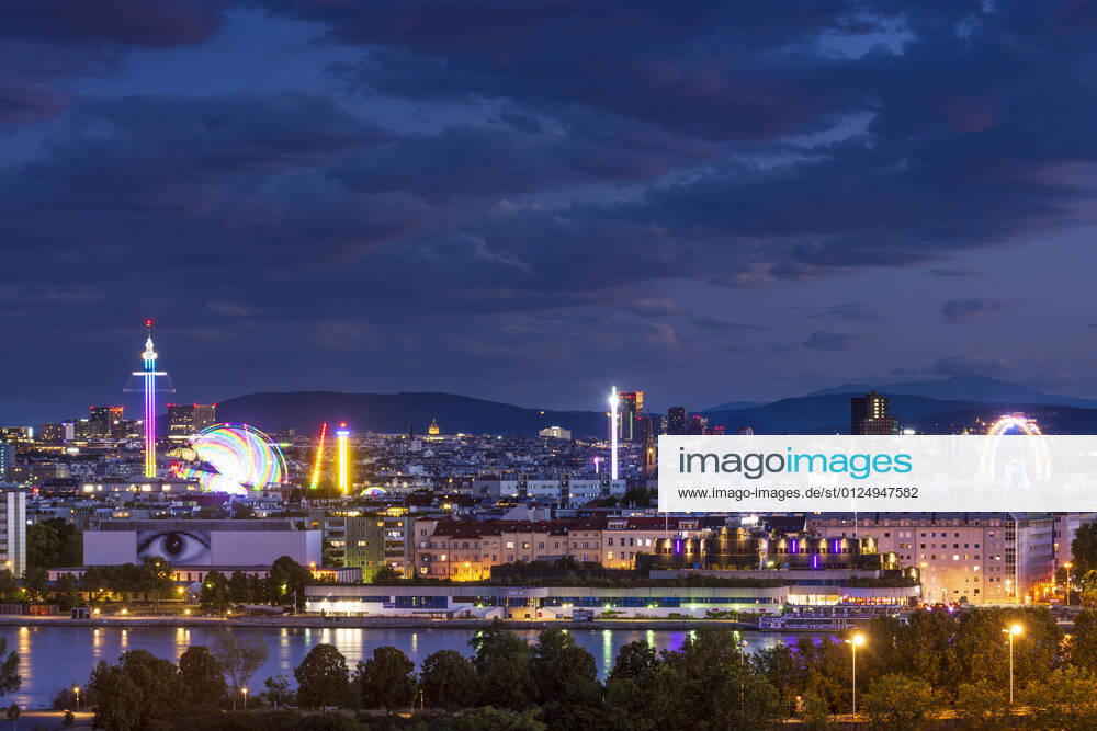 Sunset panorama of Vienna city center from North-East: , river Donau (Danube), island Donauinsel, amusement park Prater, tower Praterturm (carousel type Starflyer), Ferris Wheel, mountain Schneeberg (right) Wien, Vienna Wien Austria 00. overview