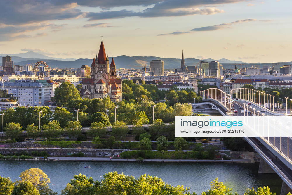 Sunset panorama of Vienna city center from North-East: , river Donau (Danube), island Donauinsel, bridge Reichsbrücke, amusement park Prater, Ferris Wheel, church Franz von Assisi, cathedral Stephansdom (St. Stephen s Cathedral) (from left to right) Wien, Vienna Wien Austria 00. overview