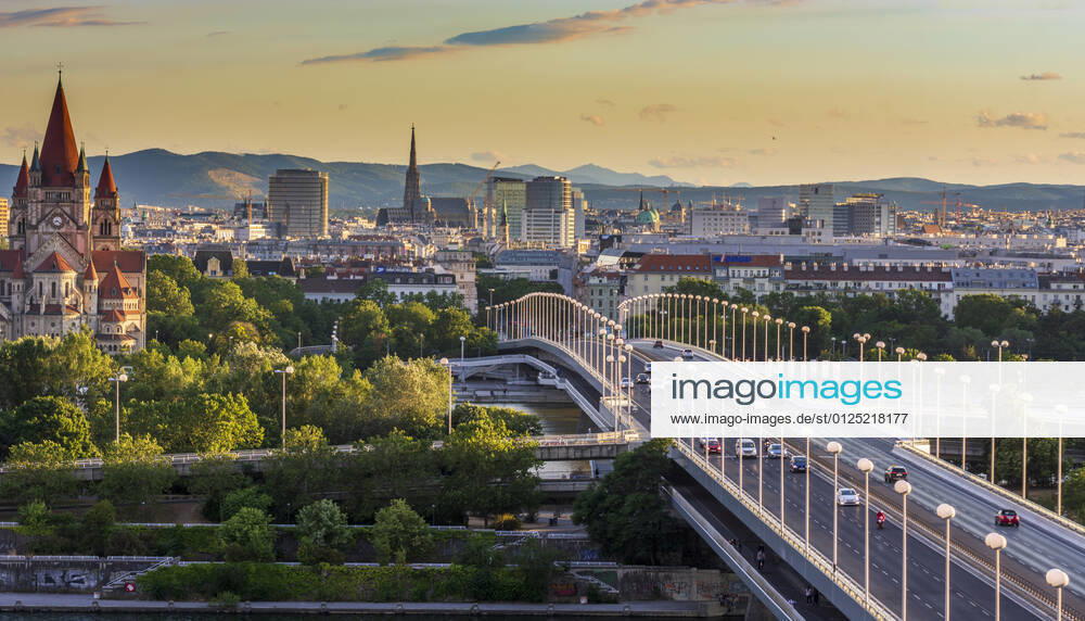 Sunset panorama of Vienna city center from North-East: , river Donau (Danube), island Donauinsel, bridge Reichsbrücke, church Franz von Assisi, cathedral Stephansdom (St. Stephen s Cathedral) Wien, Vienna Wien Austria 00. overview