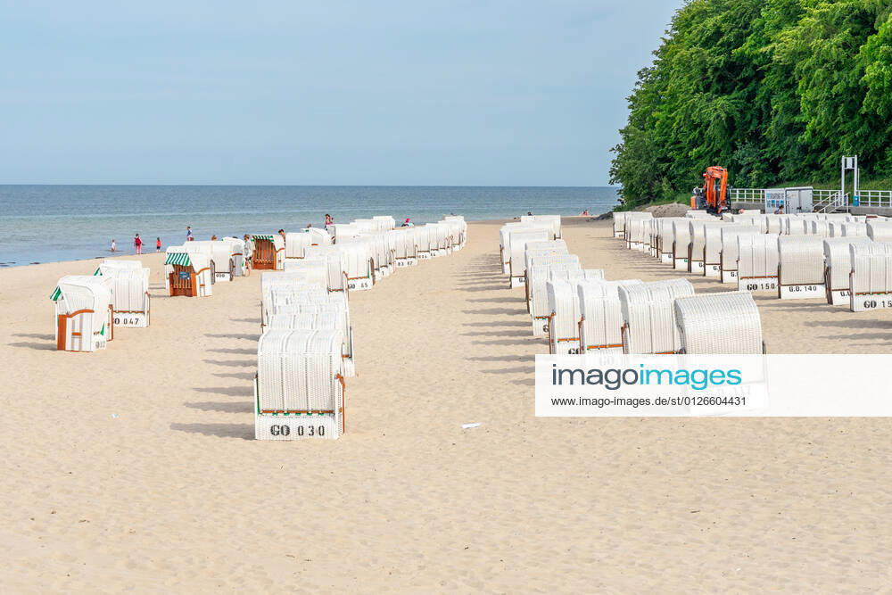 Ruegen, Sellin, Mecklenburg-Vorpommern, Germany - 10 june 2021: Holidaymakers go swimming on the beach of Sellin, several beach chairs to rest in the vacation area