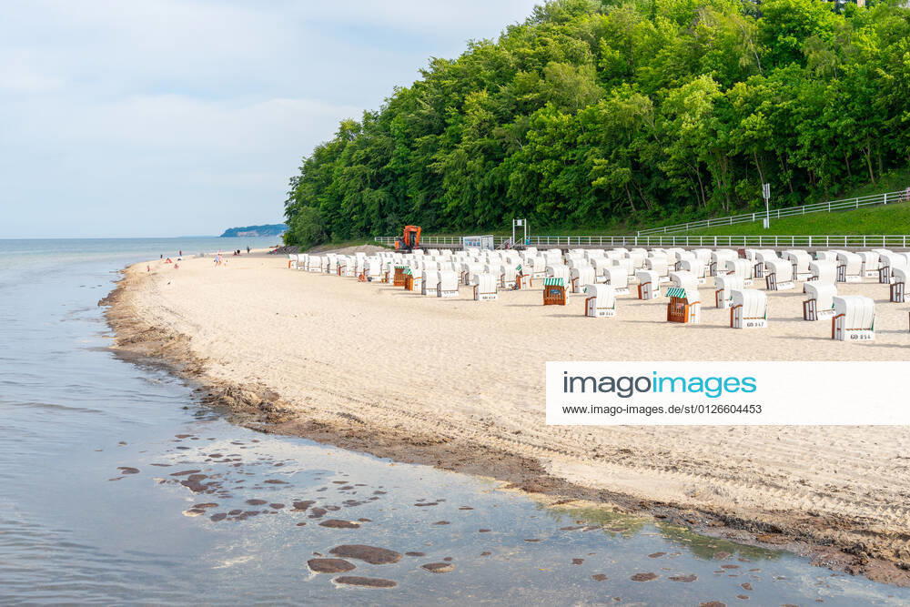 Ruegen, Sellin, Mecklenburg-Vorpommern, Germany - 10 june 2021: Holidaymakers go swimming on the beach of Sellin, several beach chairs to rest in the vacation area