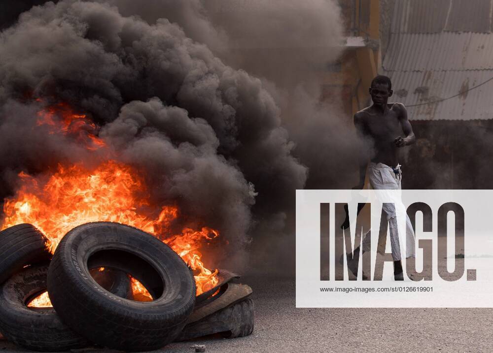 A man walks in front of a pile of burning tires during a day of protests in Cap-Haitien, Haiti, 22 July 2021. Demonstrators demanding justice to Moise set up bonfires and barricades in different points of the city, at the northern of the country, where the latest president was born. Jovenel s staunch supporters do not want his funeral, scheduled for Friday, to take place until his murderers are dead. At the moment, 26 people have been arrested for their alleged involvement in the case. Haitians pay tribute assassinated President Jovenel Moise among protests !ACHTUNG: NUR REDAKTIONELLE NUTZUNG!