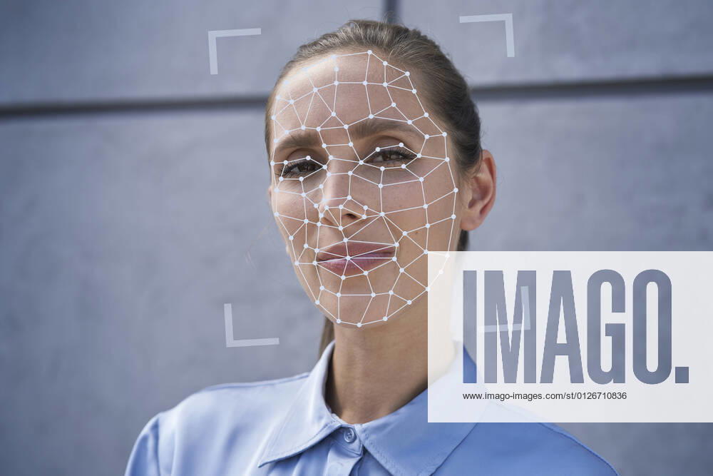 Businesswoman with facial recognition biometrics in front of wall model released Symbolfoto property released ABIF01401