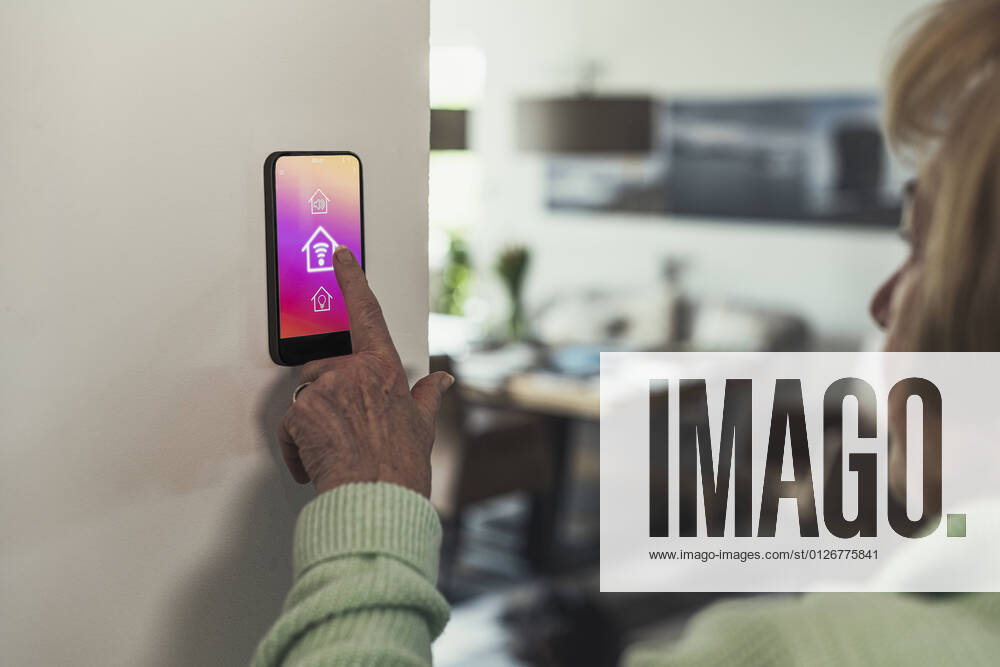 IMAGO Creative: Corporate: Klimaschutz, Digitalisierung und Urbanisierung Woman touching wifi icon on home automation device model released Symbolfoto property released UUF23651