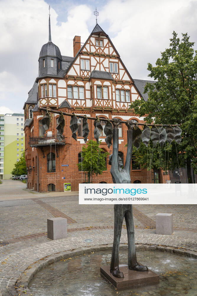 Der Tabakbrunnen vom Künstler Jan Witte-Kropius auf dem Vierradener Platz in Schwedt Oder (Landkreis Uckermark) Der Brunnen zeigt einen Arbeiter, der Tabak zum Trocknen aufhängt. Ein kleiner Teufel leht an einer Sitzgelegenheit und raucht eine Pfeife. Foto: Volker Hohlfeld Der Tabakbrunnen in Schwedt Oder