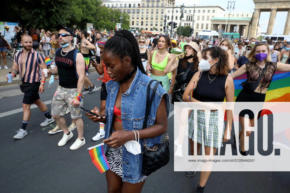 Berliner CHRISTOPHER STREET DAY 2021 - CSD - Am 24. Juli 2021 zieht der CSD in Berlin unter dem Motto SAVE OUR COMMUNITY SAVE YOUR PRIDE zum 43. Mal durch die Hauptstadt. Demoteilnehmerin trägt Regenbogenfähnchen im Demozug auf der Straße des 17. Juni. Die bunte CSD-Parade startete in diesem Jahr als Demonstration an der Leipziger Straße, führte über den Potsdamer Platz, vorbei am Denkmal für die im Nationalsozialismus verfolgten Homosexuellen zum Brandenburger Tor und über die Siegessäule zur Urania. Aufgrund der Corona-Pandemie fand die Demonstration ausschließlich unter Einhaltung der vom Berliner Senat erlassenen Vorgaben statt. Die in den Vorjahren übliche Abschlusskundgebung musste daher ausfallen.