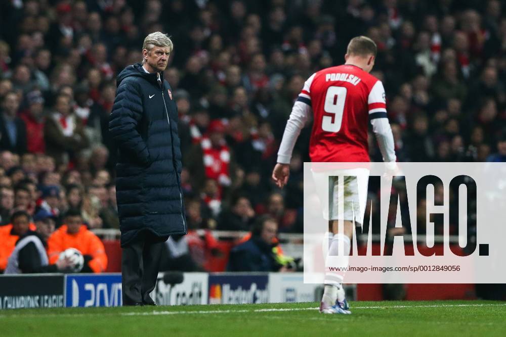 Football - 2012 2013 Champions League - Round of 16, First Leg: Arsenal vs. Bayern Munich Manager of Arsenal Arsene Wenger looks on as Lukas Podolski of Arsenal passes him with his head down at the Emirates Stadium, London