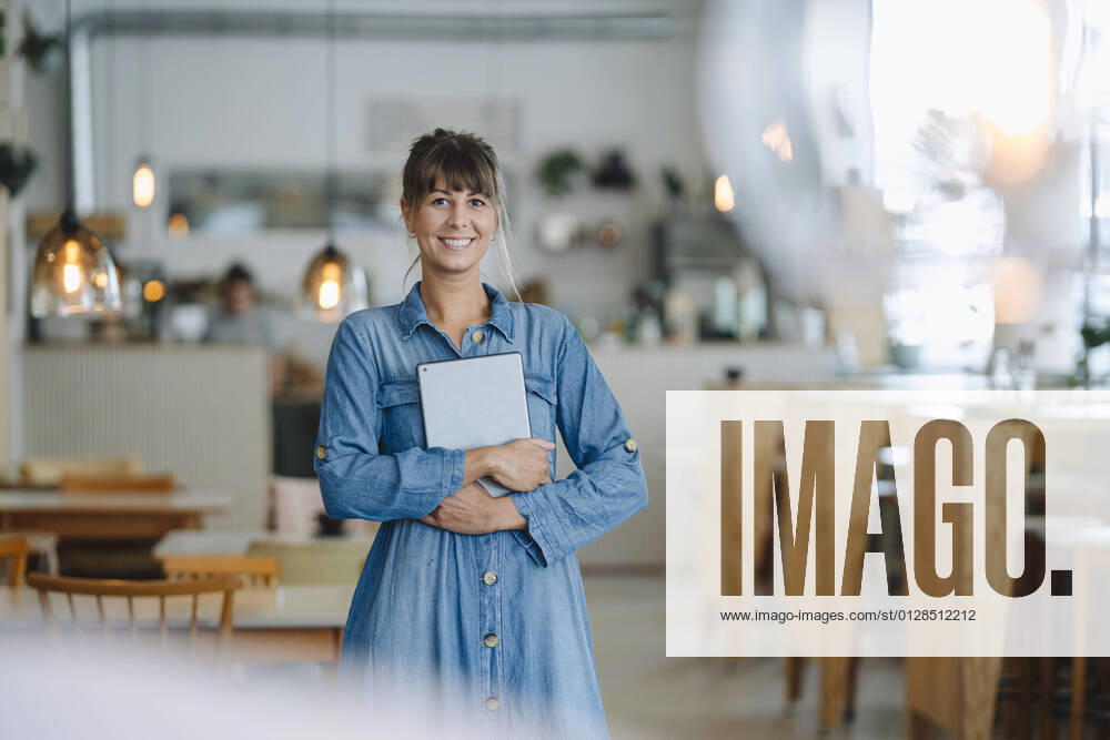 IMAGO Creative: Kreative Renaissance -- der junge Entrepreneur Happy female entrepreneur using digital tablet while standing in coffee shop model released Symbolfoto property released GUSF04624