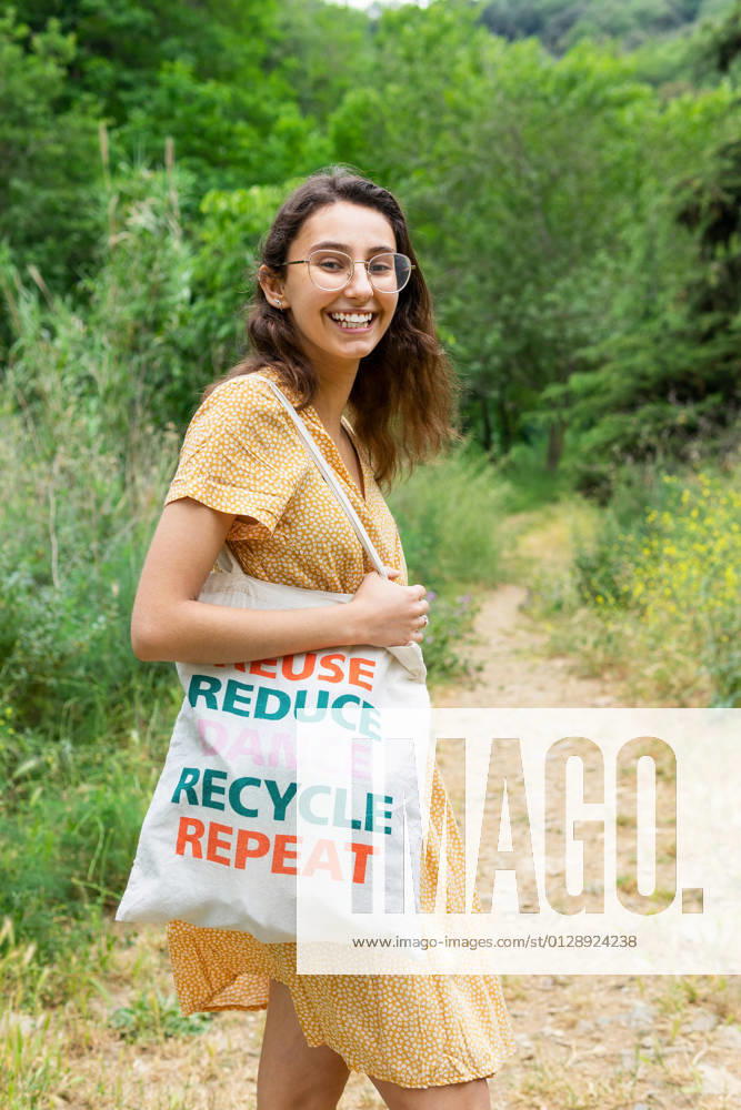 Side view of content female standing with eco friendly textile bag in summer park and looking at camera, Model released DavidMunoz_LuciaPark_26.jpg