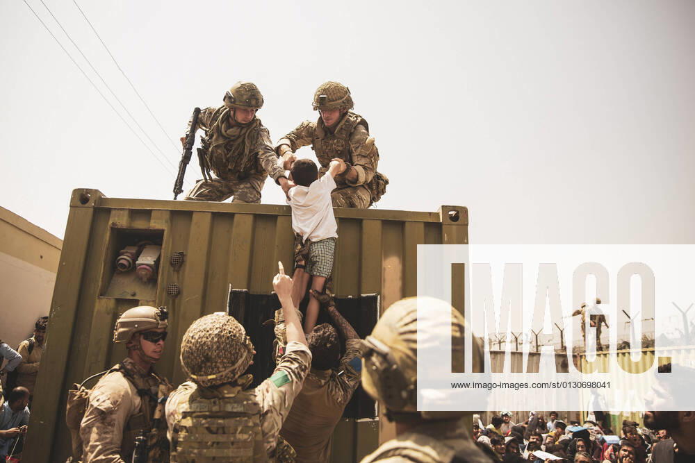 Afghanistan, Evakuierungen am Flughafen in Kabul UK coalition forces, Turkish coalition forces, and U.S. Marines assist a child during an evacuation at Hamid Karzai International Airport, in Kabul, Afghanistan, August 20, 2021. U.S. service members are assisting the Department of State with a non-combatant evacuation operation (NEO) in Afghanistan. WAX2021082002 STAFFxSGT.xVICTORxMANCILLA