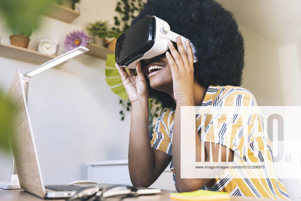 Happy young woman using virtual reality simulator at home model released Symbolfoto property released JCCMF03315