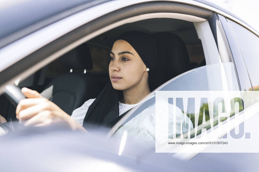 Young woman driving car model released Symbolfoto JCCMF03441