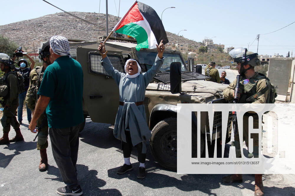 A protester chants slogans while holding a flag during the demonstration..Palestinians protest against the construction of a new road for Israeli settlers, and also call for the removal of the Israeli outpost Eviatar near Beita, south of Nablus in the West Bank. Nablus Palestine - ZUMAs197 20210825_zaa_s197_103