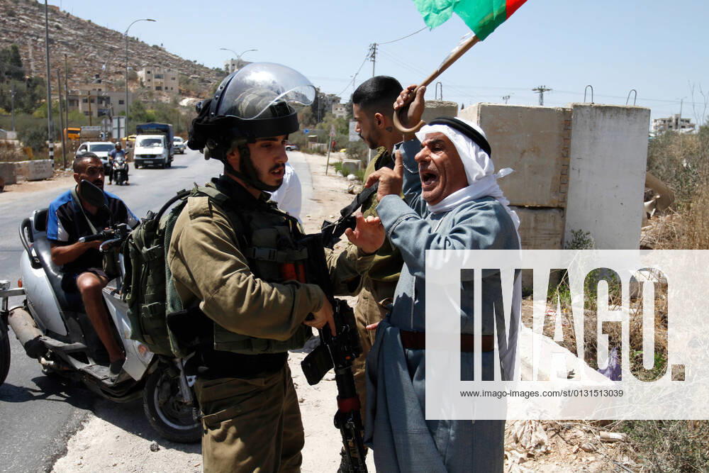 A protester chants slogans while confronting an Israeli soldier during the demonstration..Palestinians protest against the construction of a new road for Israeli settlers, and also call for the removal of the Israeli outpost Eviatar near Beita, south of Nablus in the West Bank. Nablus Palestine - ZUMAs197 20210825_zaa_s197_105