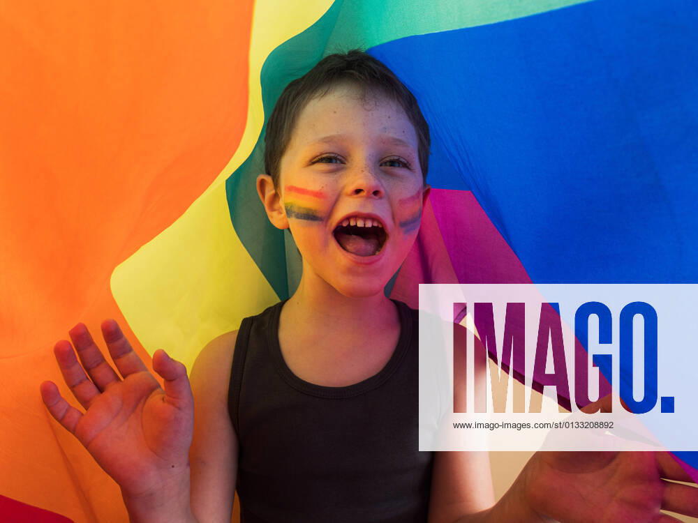 IMAGO Creative: Pride Month 2022, Engagement der Jugendlichen Positive child in undershirt with makeup on cheeks and open mouth yelling while looking away under LGBTQ flag HodeiUnzueta_EtxahumStudioConcepts_62.jpg