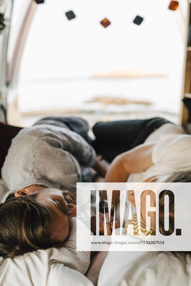 Male friends lying on side at camping van during vacation Sweden, Gothenburg, model released, property released