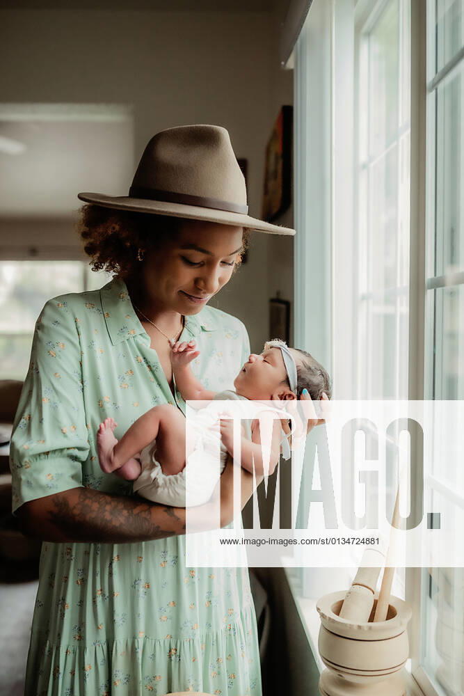 Young black mother holding her baby daughter by a window San Diego, California, United States CR_CHDO21082504-784602-01 ,model released, Symbolfoto