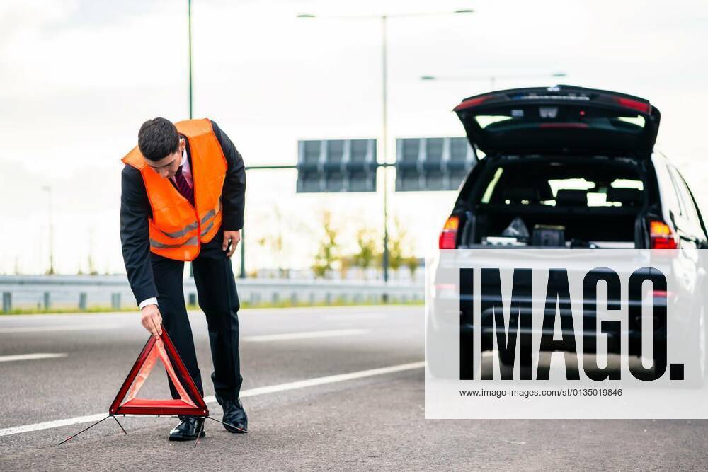 Man with car breakdown erecting warning triangle model released, Symbolfoto, 11.10.2020,