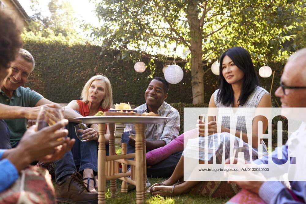 Group Of Mature Friends Enjoying Drinks In Backyard Together model released, Symbolfotoproperty released, , 11.10.2020,