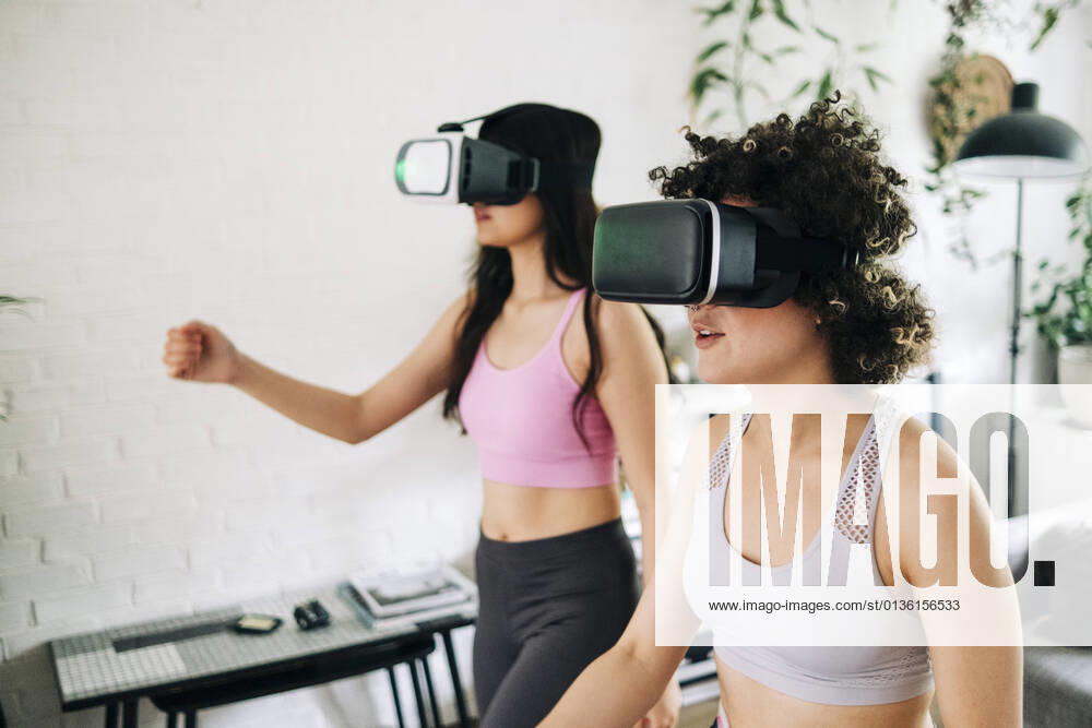 Friends with virtual reality headsets exercising together at home model released Symbolfoto property released ASGF01108