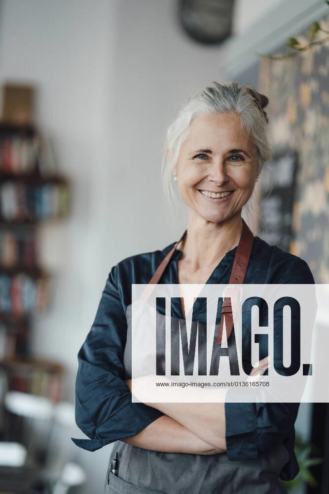Female entrepreneur standing with arms crossed in cafe model released Symbolfoto property released JOSEF05889