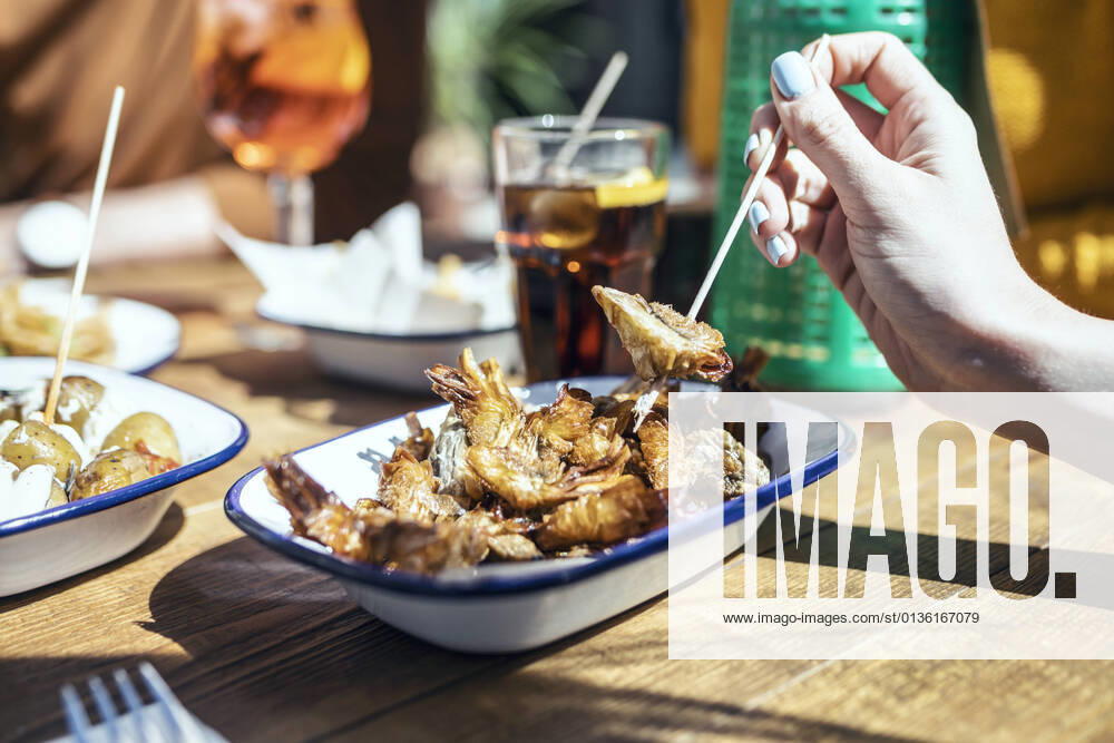 IMAGO Creative, Food, Tapas Woman having fried prawn in restaurant model released Symbolfoto property released JSRF01578