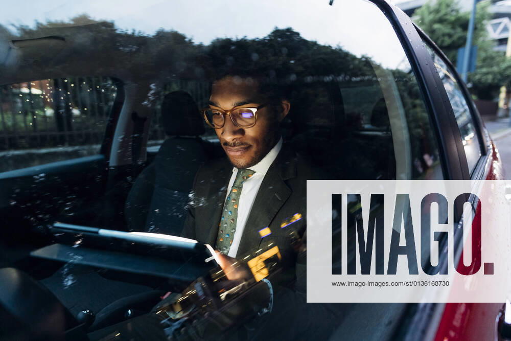 Young businessman using digital tablet while sitting in car model released Symbolfoto MEUF04176