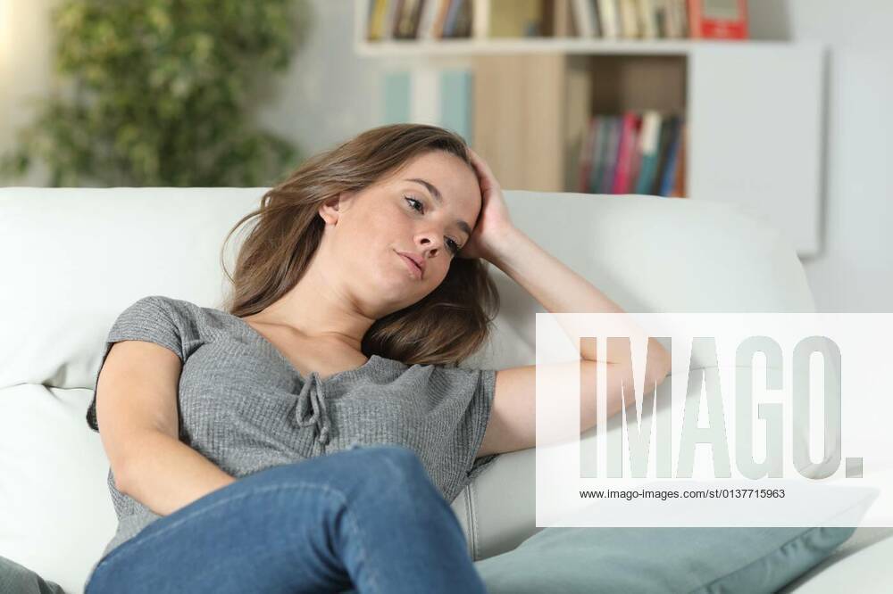 Sad woman looking away sitting on a couch at home model released, Symbolfoto, 13.10.2020,