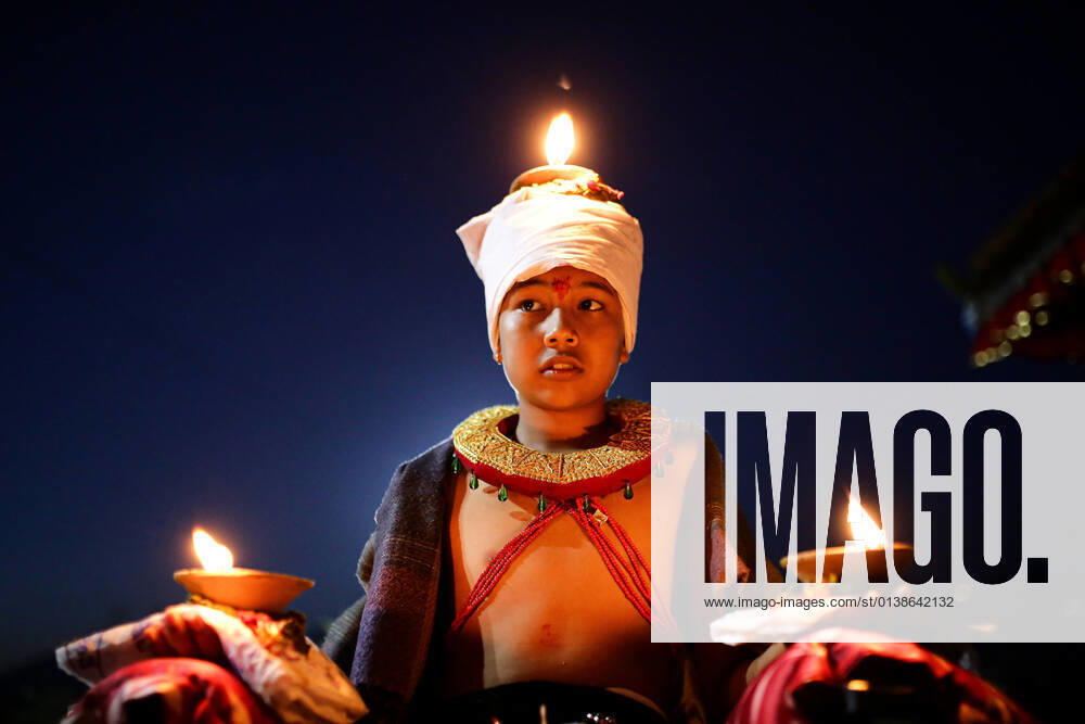 A young devotee holds burning oil lamps on his head and palms while offering prayers as part of a ritual on the tenth day of the Dasain festival in Bhaktapur s Bramayeni temple. Dashain festival symbolizes the victory of good over evil and is considered the greatest and longest festival for the Nepalese Hindu s. Bhaktapur Nepal - ZUMAm204 20211015_zip_m204_032