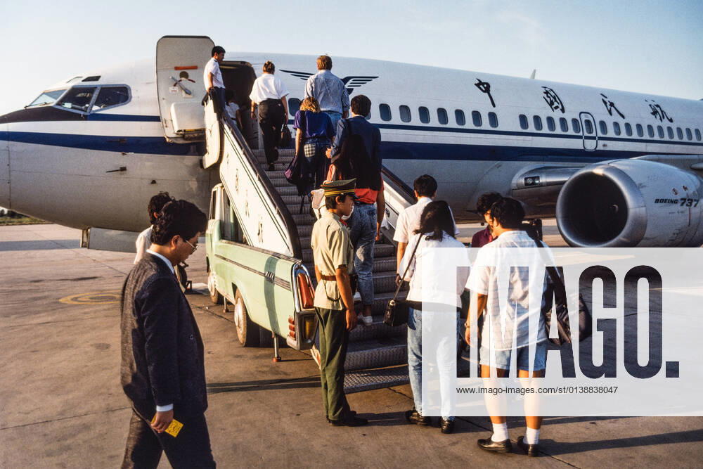 Tourists board a Chinese C.A.A.C. China Airlines Boeing 737 at the Tianjin Airport in Tianjin, China. Tianjin China