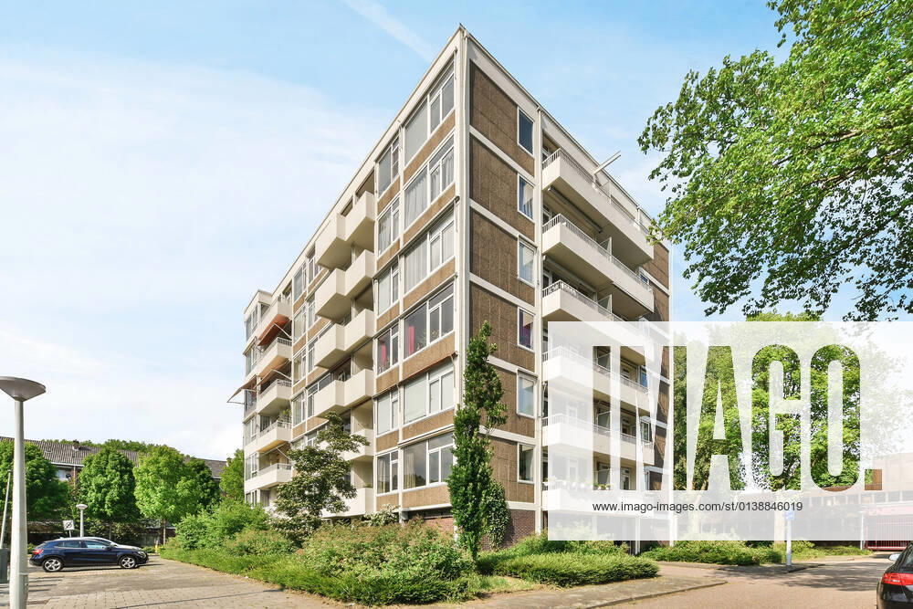 Creative design of masonry multistory building exterior with balconies between overgrown trees under light sky in Amsterdam North Holland, Property released CasaMedia_VanBoshuizenstraat465_2.jpg