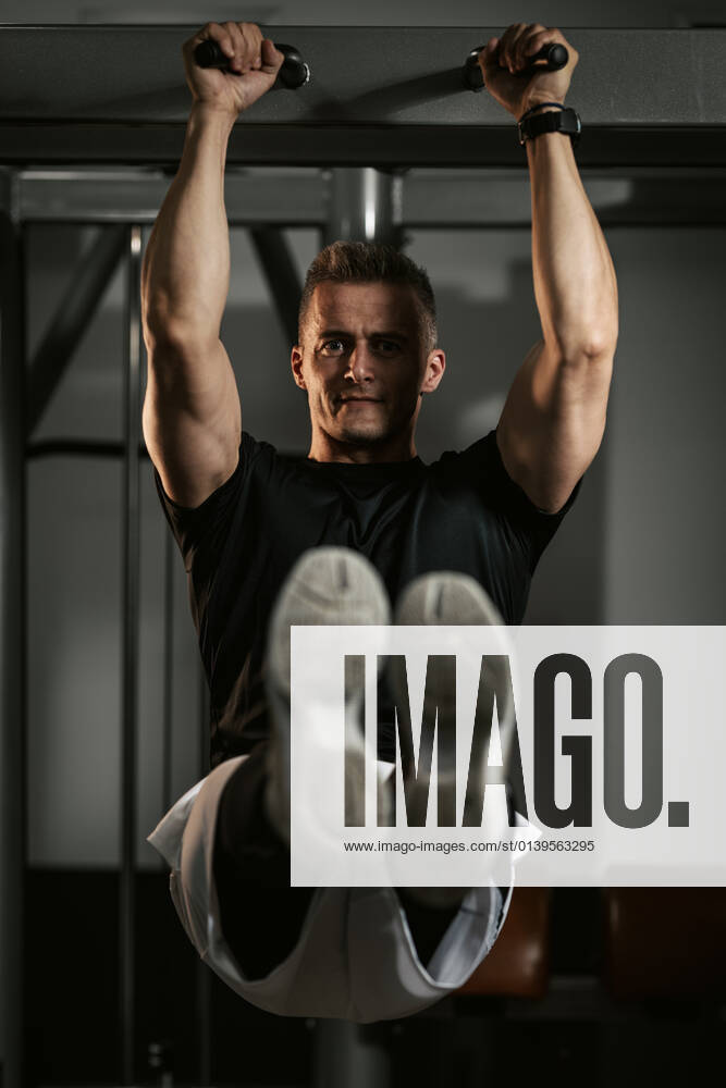 Fitness For Healthy Lifestyle Muscular young man in sportswear focused on doing sit-up exercises during a strength training workout at the gym.