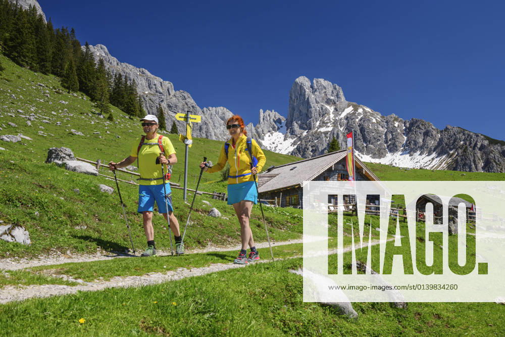 Mature male and female friends hiking at Stuhlalm Hutte on mountain during vacations model released Symbolfoto ANSF00033