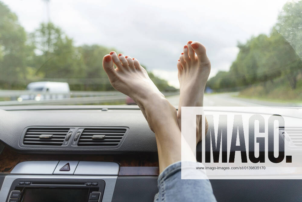 Mature woman with feet up on car dashboard model released Symbolfoto CHPF00788
